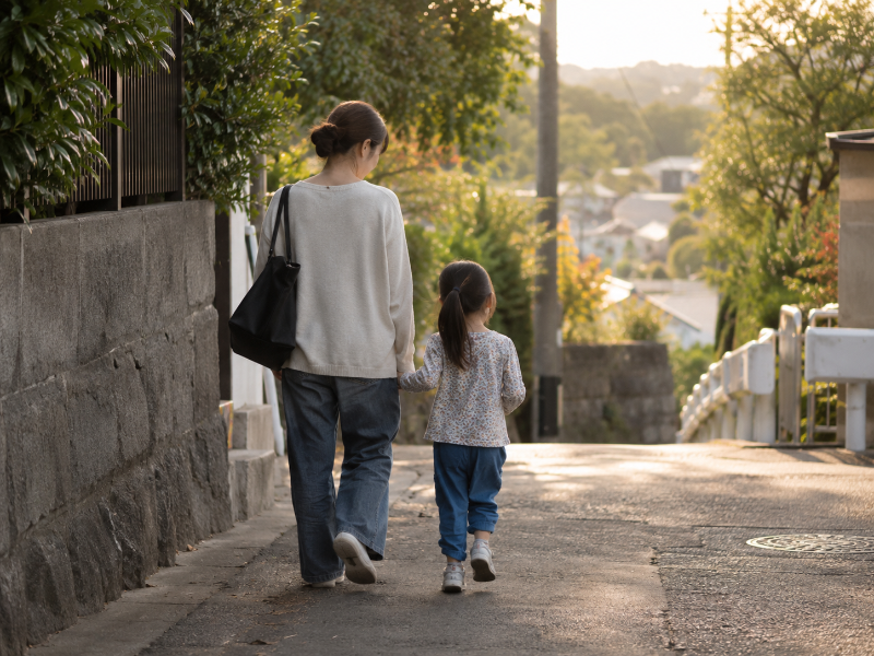 少し成長した子どもと親が一緒に歩く後ろ姿
